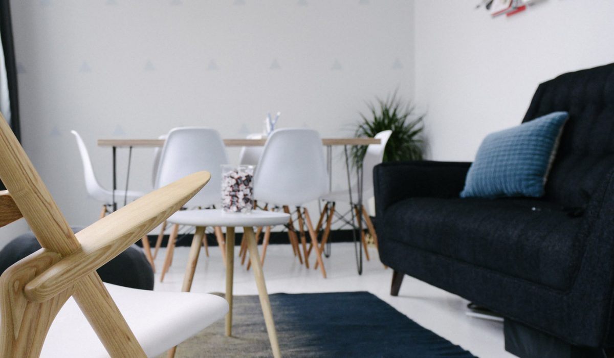header-space-calc-1 Navy couch, white coffee table and dining setting in open plan living space