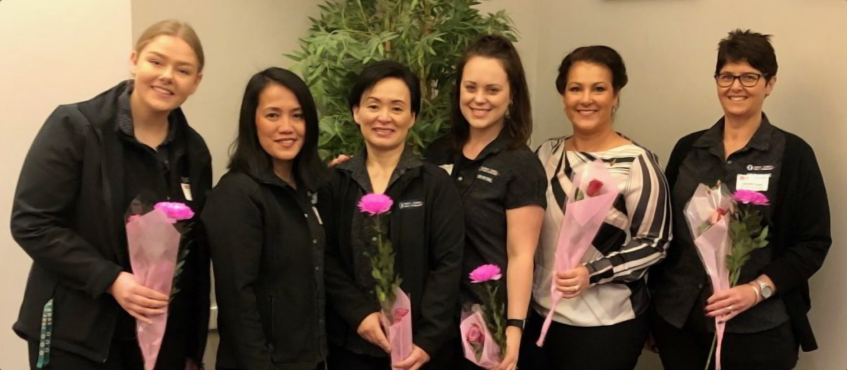 Six Female Fort Knox Self Storage staff members with flowers