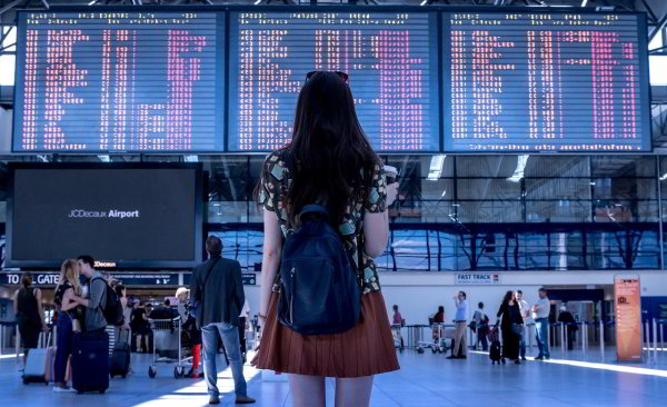 woman at airport looking at departures board