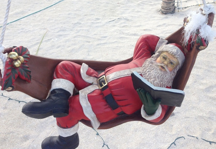 Santa Claus in a hammock reading a book